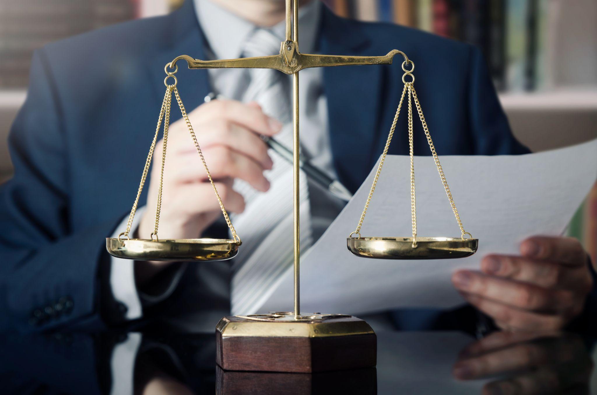 Weight scale of justice, lawyer in background